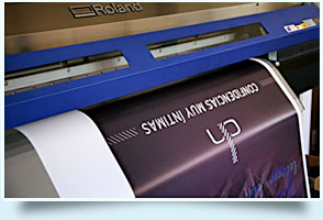 una maquina de impresion en gran formato imprimiendo un cartel para gran formato 