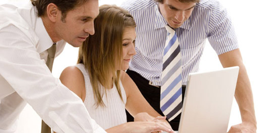 tres consultores miran discuten sobre un ordenador portatil